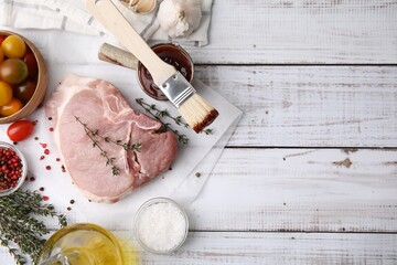 Flat lay composition with raw meat, thyme and marinade on rustic wooden table. Space for text