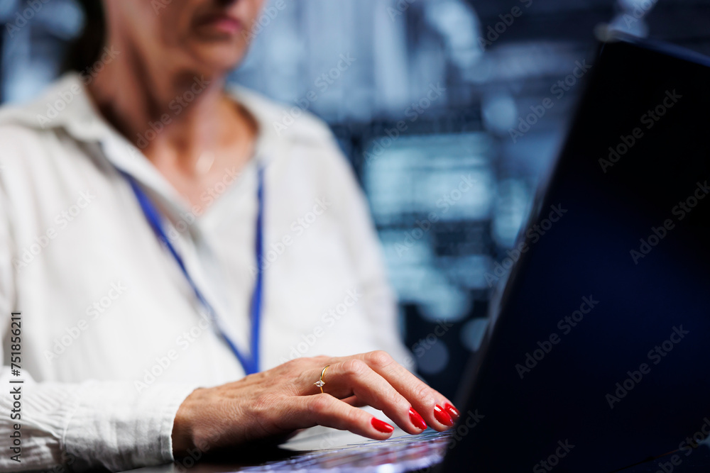 Poster elderly it expert in server hub using laptop ensuring valuable data remains shielded from potential 