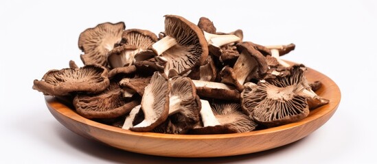 A wooden bowl filled with mushrooms sits atop a table, showcasing a bountiful harvest of fungi. The earthy tones of the mushrooms contrast beautifully with the warm hues of the wooden bowl.
