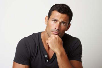 Portrait of a pensive man looking at camera against white background