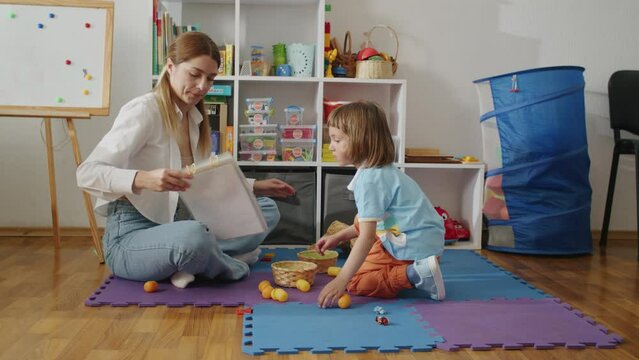 Adult reading to a child during playtime in a colorful and organized playroom. Early literacy and parent-child bonding concept. Design for family lifestyle blogs, educational parenting guides, and