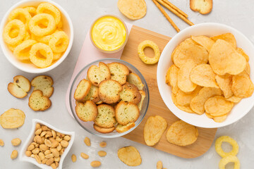 Different tasty snacks with sauce on concrete background, top view