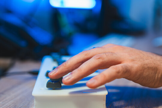 Cropped anonymous hand tuning audio device in a recording studio