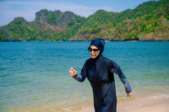 Muslim woman enjoying beach time in a burkini