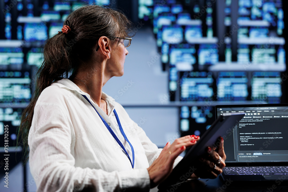 Poster elderly programmer writing script code in data center on laptop terminal. proficient specialist doin