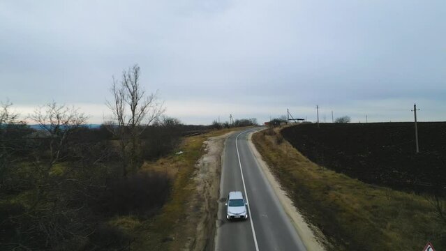 Aerial drone shot - A Car driving through a road