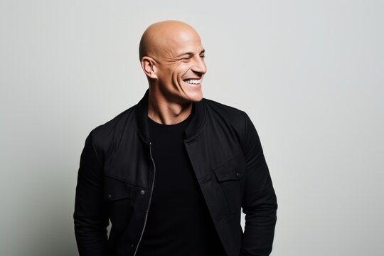 Portrait of a smiling mature bald man in a black jacket.