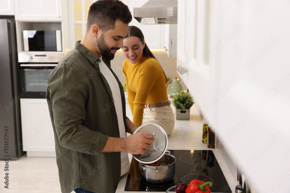 Wall mural lovely young couple cooking together in kitchen