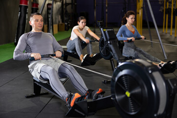 Fototapeta na wymiar Strong sportsman training at cable row machine in modern crossfit gym