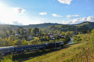 Train winds its way through picturesque landscape of the Vorokhta village consists of various small...