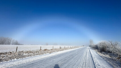 Fototapeta na wymiar Ice rainbow in the winter along a country road with snow