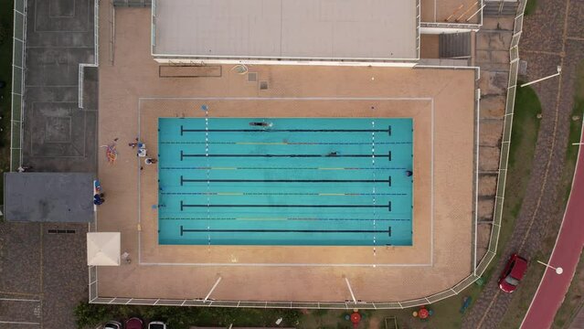 Small olympic pool with swimmers training in Salvador, Bahia, top view