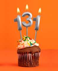 Birthday cupcake with number 131 candle - Orange color background