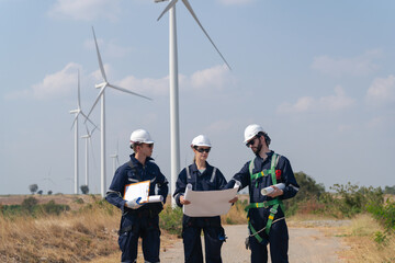 Engineers man and woman inspecting construction of WIND TURBINE FARM. WIND TURBINE with an energy storage system operated by Super Energy Corporation. Workers Meeting to check AROUND THE AREA.