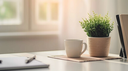 Close up view of simple workspace with laptop, notebooks, coffee cup and tree pot on white table with blurred office room background - obrazy, fototapety, plakaty