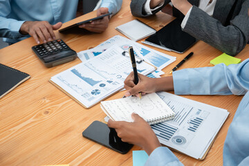 Multiracial analyst team use BI dashboard data to analyze financial report on meeting table. Group...