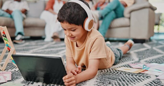 Child, headphones and education on floor with tablet for support, math game or virtual class. Boy, tech and relax in living room with streaming for language development, knowledge and elearning