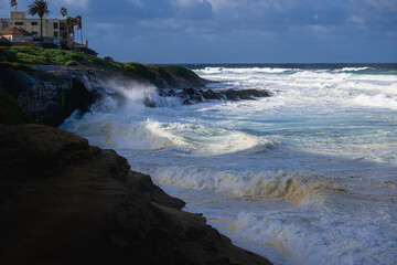 2023-1-31 MULTIPLE WAVES CRASHING ON THE SHORELINE IN LA JOLLA CALIFORNIA DURING A STORM WITH A CLOUDY SKY AND THE ROCKY SHORELINE NEAR SAN DIEGO CALIFORNIA