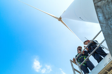 engineers working in fieldwork outdoors. Workers check and inspect construction and machine around the building project site. Wind turbines for electrical clean energy and environment sustainability.