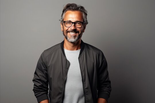 Handsome middle aged Indian man in a black jacket and glasses.