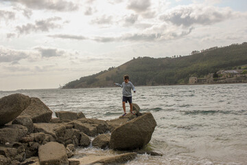boy exploring the rocks in a beach
