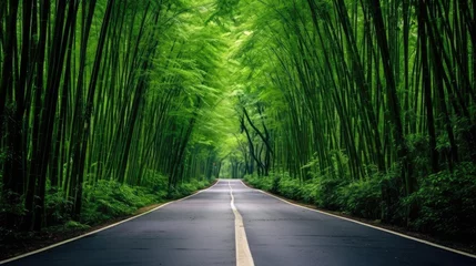 Tuinposter Photo of a long road in the middle of very green bamboo © ismodin