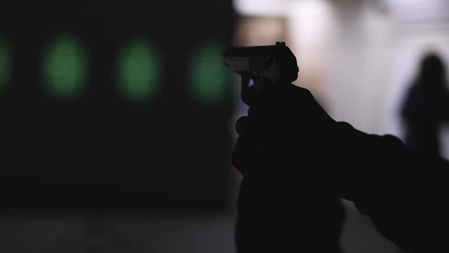 Process of shooting target at the shooting rifle range, women practicing with hand gun pistol at shooting gallery, firearms training, pointing weapon on digital screen, live fire digital targeting 