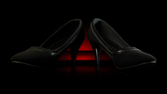 Elegant black high heels on a dark background