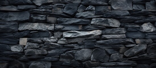 A black and white photograph showcasing the intricate patterns and textures of a stone wall. The...