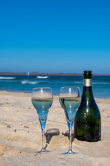 Pouring a glass of champagne on vacation, south of Fuerteventura, Canary islands, blue ocean, mountains