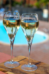 Pouring a glass of champagne on vacation, south of Fuerteventura, Canary islands, blue ocean, mountains