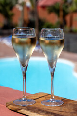 Pouring a glass of champagne on vacation, south of Fuerteventura, Canary islands, blue ocean, mountains