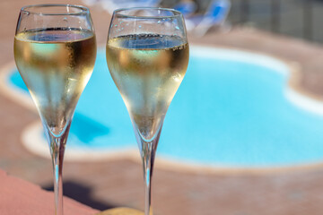 Pouring a glass of champagne on vacation, south of Fuerteventura, Canary islands, blue ocean, mountains