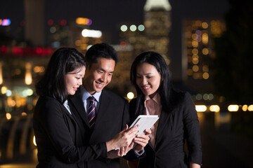 Chinese Business team in city at night.