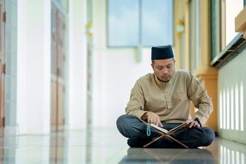 Ramadan, Quran, Islam,  An Asian Muslim man is sitting and reading the Quran. The peace in the...