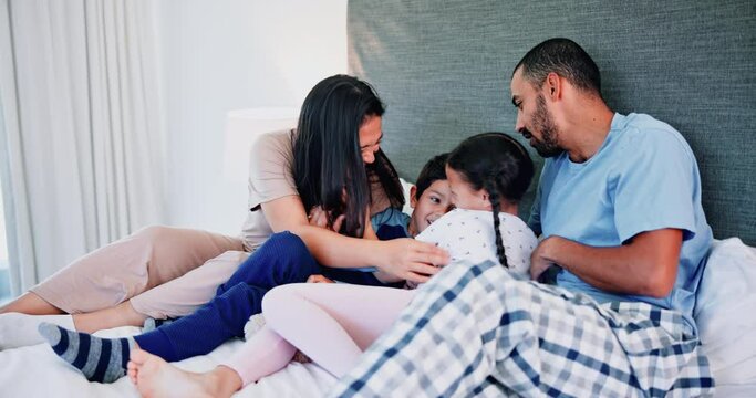 Laughing, tickling and kids in bed with parents relaxing and bonding together at home with teddy bear. Happy, fun and children resting and playing with mother and father in bedroom at house.