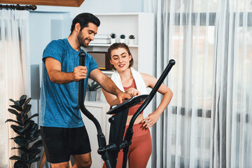 Athletic and sporty young couple or fitness buddy running on running machine together, home body...