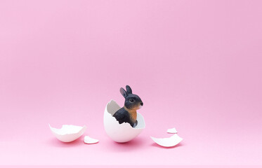 Minimal Easter card with a bunny hatching from an egg. Creative spring postcard. Selective focus,...