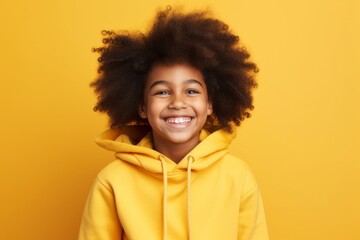 Obraz na płótnie Canvas Portrait of cute african american little girl in yellow hoodie on yellow background