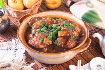 Stewed pork trotters in brown sauce in clay pot