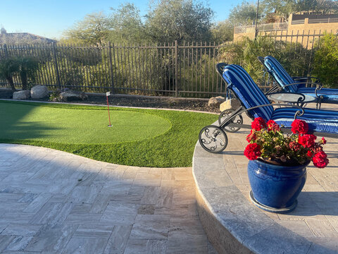 A Artificial putting green in a desert landscaped backyard.