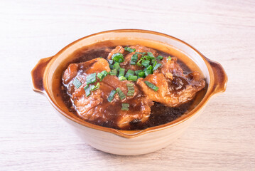 Stewed pork trotters in brown sauce in clay pot