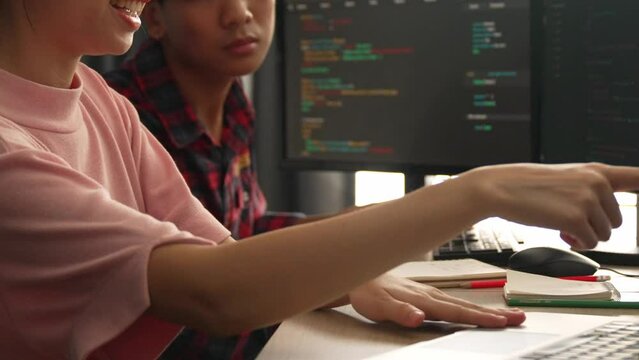 Slow motion back end software developer engineer for computer programming working together on debugging writing computing code, solving complex algorithms display on monitor in office. Burgeoning
