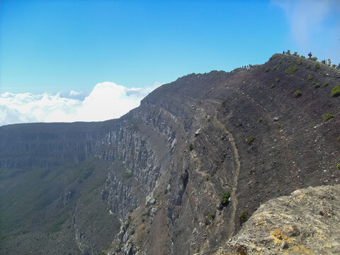 View of the rocky active crater wall of Mount Gede Pangrango with blue sky, West Java, Indonesia