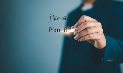 Business plan strategy changing.The man crossing over Plan A, writing Plan B.Concept is ....