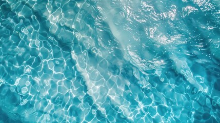 Background of blue water surface in swimming pool with sun reflections.