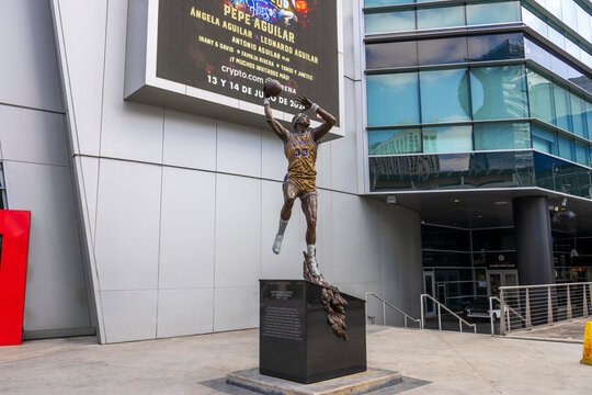A statue of Kareem Abdul-Jabbar shooting a basketball with his sky hook shot wearing a Lakers uniform with the number 33 in front of Crypto.com Arena in Los Angeles California USA.