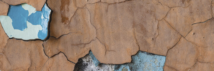 Peeling paint on the wall. Panorama of a concrete wall with old cracked flaking paint. Weathered...