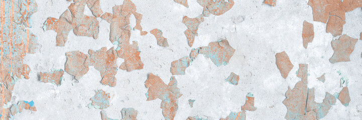 Peeling paint on the wall. Old concrete wall with cracked flaking paint. Weathered rough painted surface with patterns of cracks and peeling. Grunge texture for background and design. High resolution.