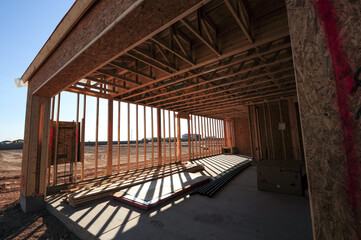 Fototapeta premium A wide-angle perspective captures the garage area of a wooden home under construction in southeastern Maricopa County, Arizona